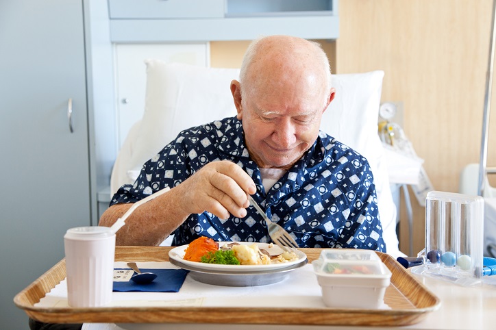 starszy mężczyzna jedzący obiad